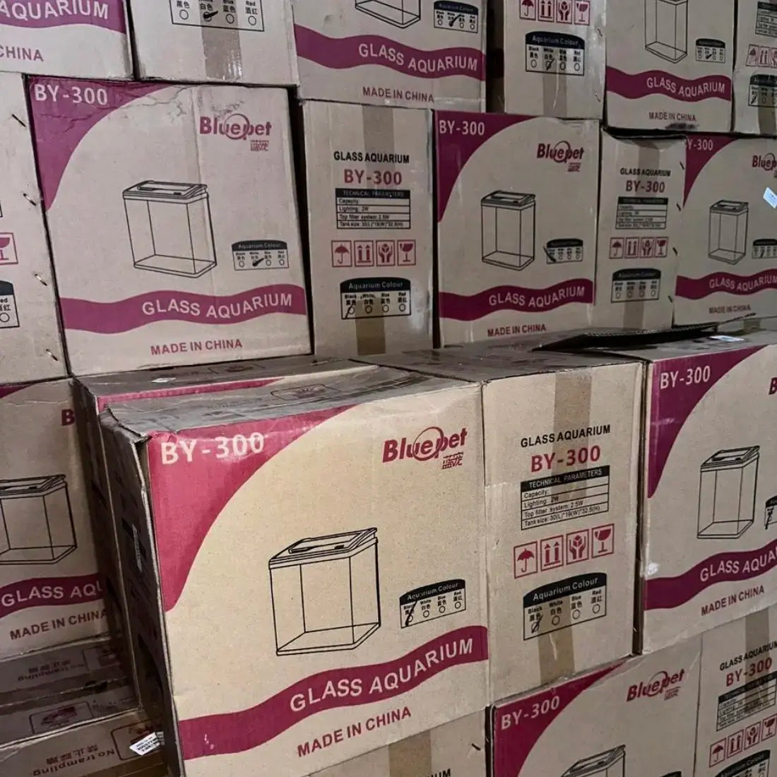 Stack of Bluepet glass aquarium boxes with visible branding and product details.